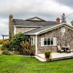 Cottage One features a large deck on three sides of the building, with an attached trellis on the front side overlooking the bay.